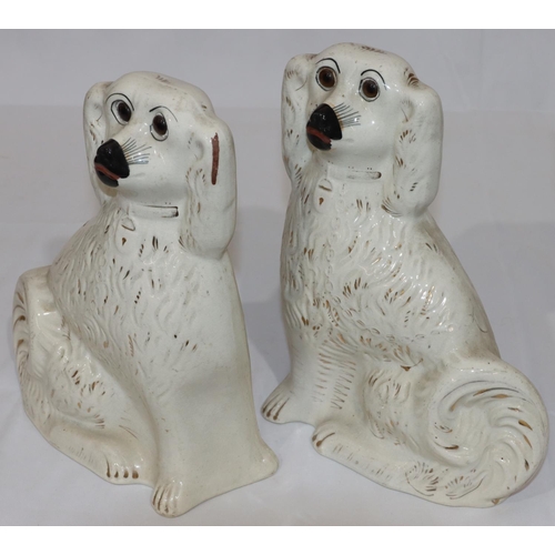 89 - A pair of 19th Century Staffordshire figures of seated spaniels with gilt decoration and glass eyes ... 