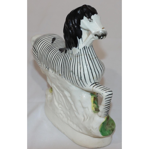 90 - A 19th Century Staffordshire figure of a Zebra, 22.5cm high (crack around neck and top front right l... 