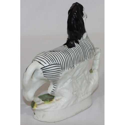 90 - A 19th Century Staffordshire figure of a Zebra, 22.5cm high (crack around neck and top front right l... 