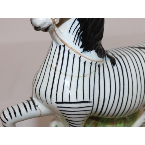 90 - A 19th Century Staffordshire figure of a Zebra, 22.5cm high (crack around neck and top front right l... 