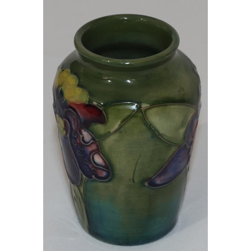 99 - A Moorcroft small round thin necked vase on green ground with multi-coloured floral and leaf decorat... 