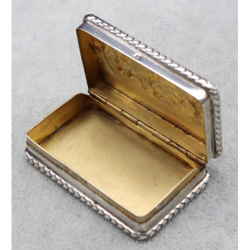 300 - A London silver small rectangular shaped snuff box with embossed figure decorated hinged lid, 5.7cm ... 