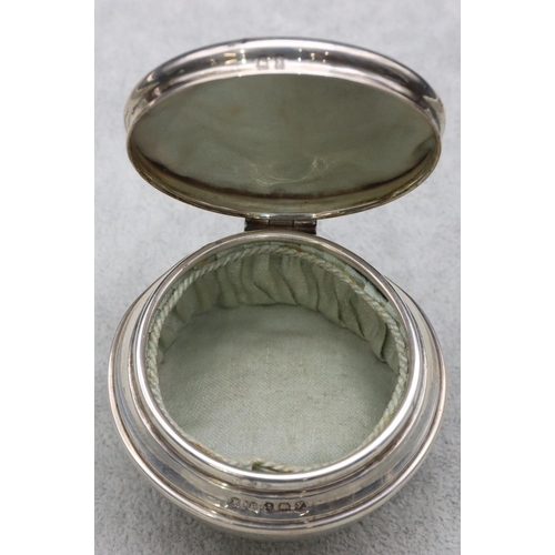 304 - A Birmingham silver round bulbous shaped trinket box with hinged lid enclosing silk interior on 3 ba... 