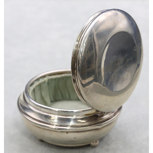 304 - A Birmingham silver round bulbous shaped trinket box with hinged lid enclosing silk interior on 3 ba... 