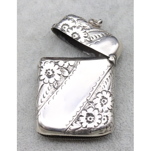 322 - A large Birmingham silver concave shaped vesta case with embossed floral and leaf decoration and hin... 