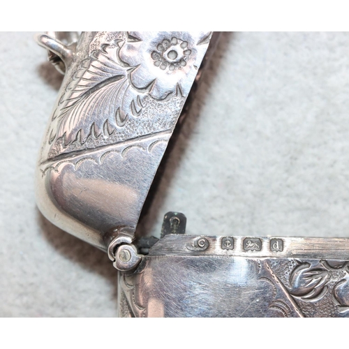 322 - A large Birmingham silver concave shaped vesta case with embossed floral and leaf decoration and hin... 