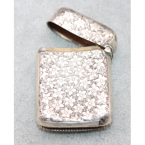 331 - A Birmingham silver concave shaped vesta case with chased leaf and floral decoration and hinged lid,... 