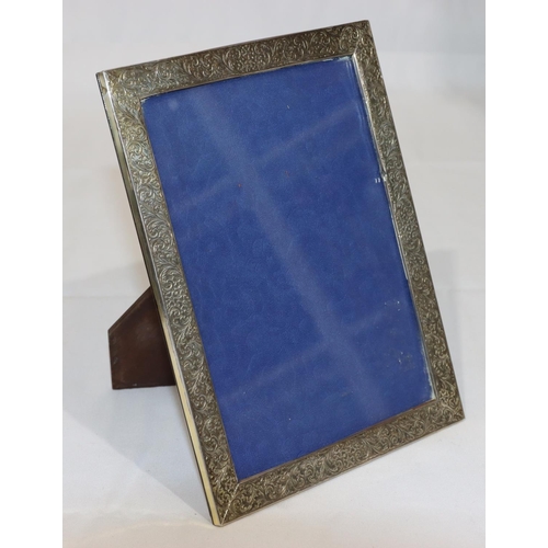 364 - A 925 silver mounted freestanding photograph frame with chased floral and scroll decoration, 21cm hi... 