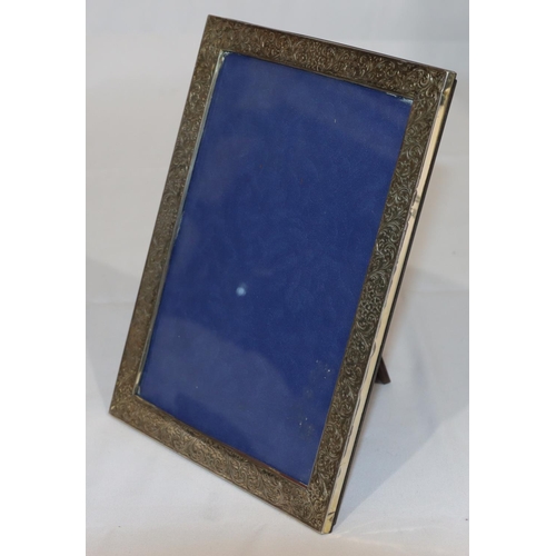 364 - A 925 silver mounted freestanding photograph frame with chased floral and scroll decoration, 21cm hi... 