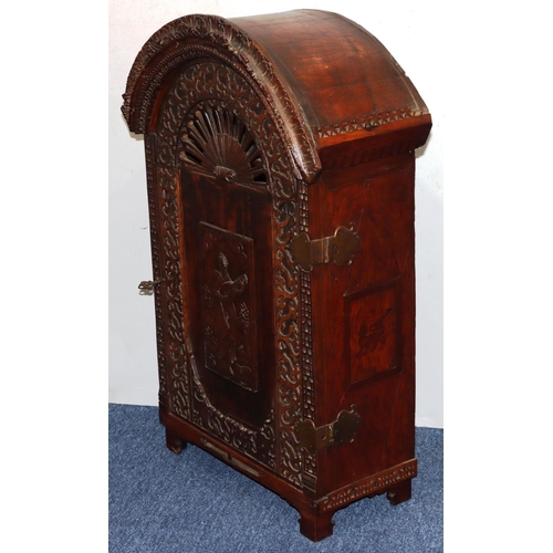 732 - An oak domed table topped cabinet, single panel door with raised carved and pierced figure, leaf and... 