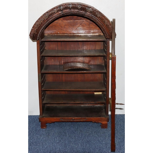 732 - An oak domed table topped cabinet, single panel door with raised carved and pierced figure, leaf and... 