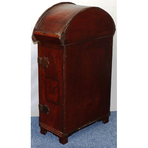 732 - An oak domed table topped cabinet, single panel door with raised carved and pierced figure, leaf and... 