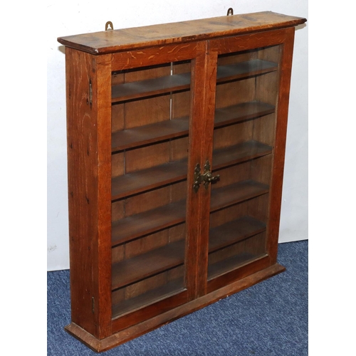 737 - An oak hanging narrow cabinet with 2 glass panel doors enclosing shelves, 66cm wide, 13.5cm deep, 70... 