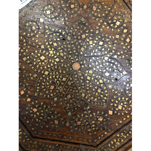 731 - An Eastern octagonal shaped coffee table with brass and copper inlaid floral, leaf and scroll decora... 