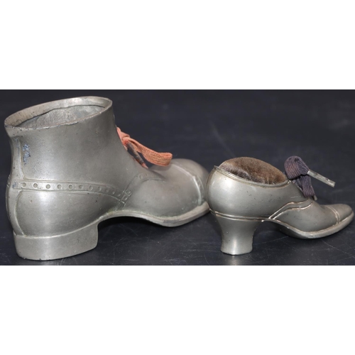 534 - A pewter pin cushion in the form of a lady's shoe, 9.5cm long and a larger pewter boot, 14.5cm long ... 