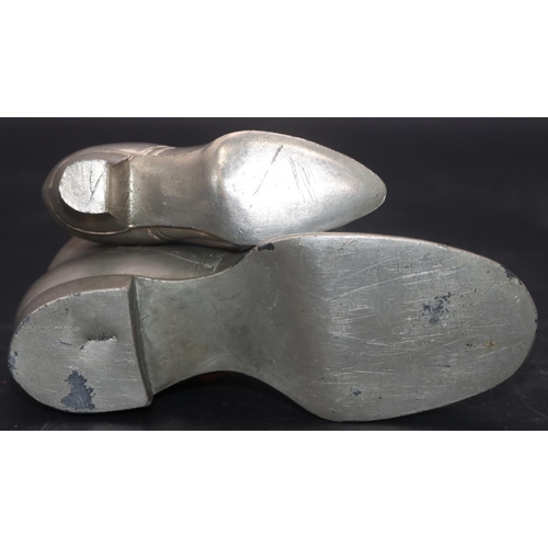 534 - A pewter pin cushion in the form of a lady's shoe, 9.5cm long and a larger pewter boot, 14.5cm long ... 