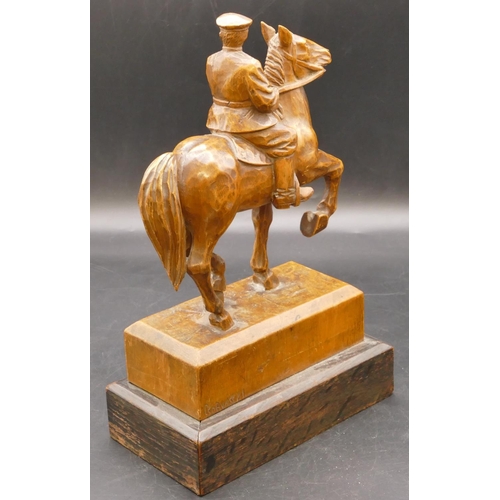 665 - A 19/20th Century carved wooden statue of a soldier on horseback, indistinctly signed and mounted on... 