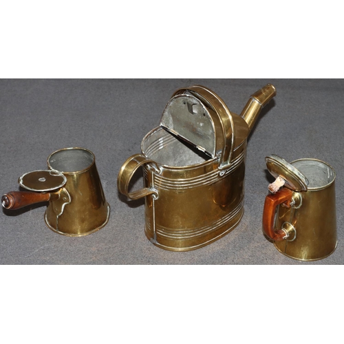 577 - An oval brass watering can with fixed overhead handle (handle in need of restoration) and 2 brass li... 