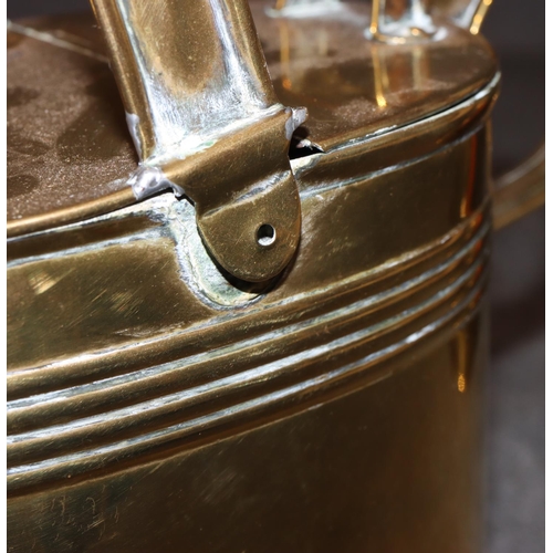 577 - An oval brass watering can with fixed overhead handle (handle in need of restoration) and 2 brass li... 