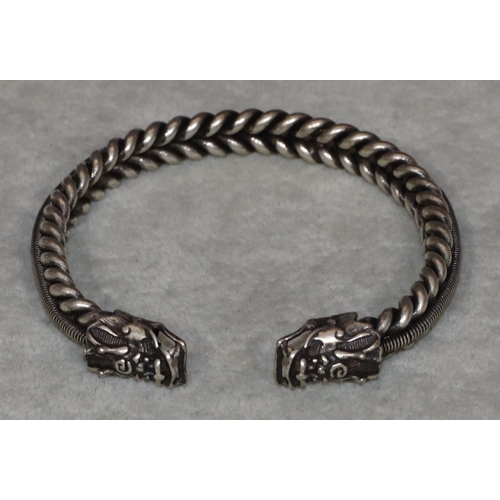 454 - An Oriental silvered metal bangle with 2 dragon heads