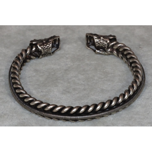 454 - An Oriental silvered metal bangle with 2 dragon heads