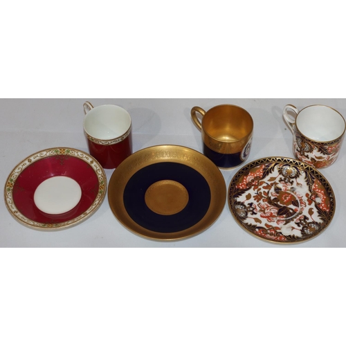 130 - A Royal Worcester coffee can and saucer on royal blue and gilt ground with oval painted crest (sauce... 