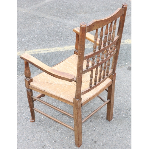 922 - An oak spindle back armchair with rush seat and turned stretchers