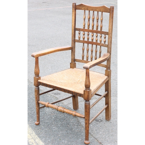 922 - An oak spindle back armchair with rush seat and turned stretchers