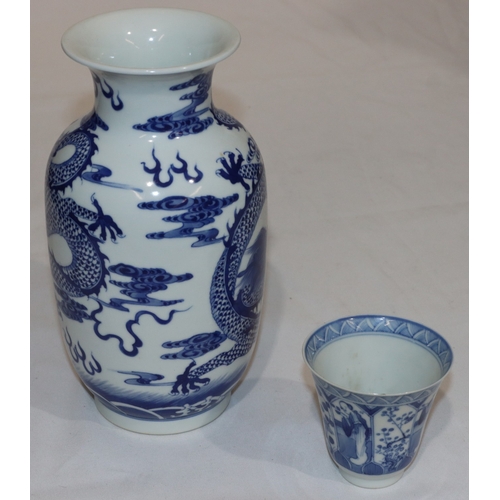 115 - An Oriental blue and white round bulbous trumpet shaped vase with dragon decoration, 21.5cm and an O... 