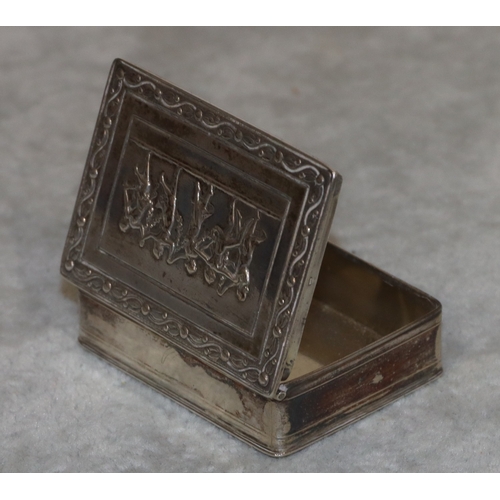 187 - A Continental silver coloured metal rectangular shaped snuff box with hinged lid and embossed figure... 