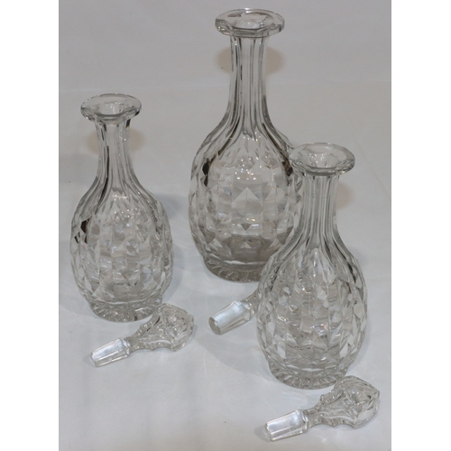 20 - A set of 3 heavy cut glass round bulbous thin necked decanters with stoppers, comprising of a pair, ... 