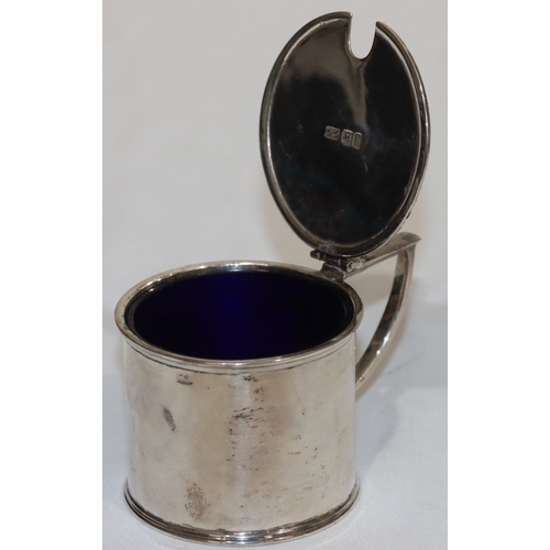 212 - An Edward VII silver round mustard pot with hinged lid enclosing blue glass liner, London 1903, make... 