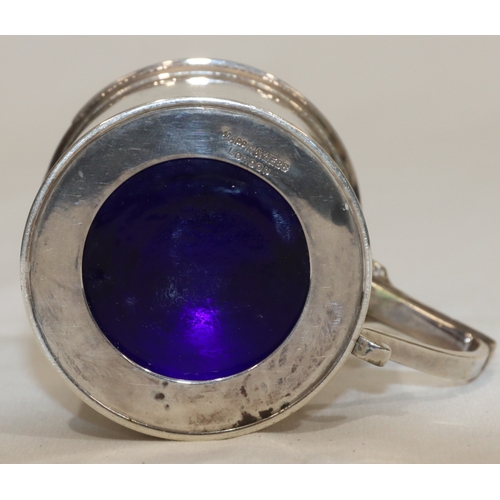 212 - An Edward VII silver round mustard pot with hinged lid enclosing blue glass liner, London 1903, make... 