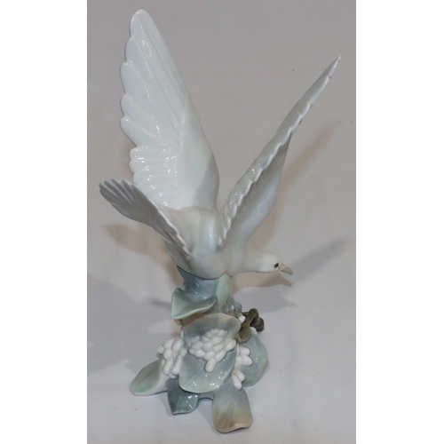 25 - A Lladro figure of a white bird perched on branch, 28cm high