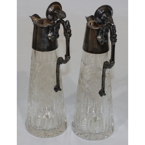 257 - A pair of modern cut glass claret jugs with silver necks, hinged lids, scroll handles and mask head ... 