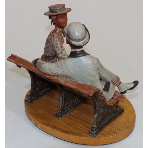 30 - Bill Dowsett, painted earthenware group of lady and gentleman seated on park bench, mounted on oval ... 