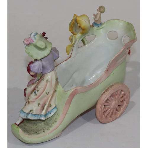 34 - A Continental china jardiniere in the form of a shoe on wheels with raised figure and cupid motif, a... 