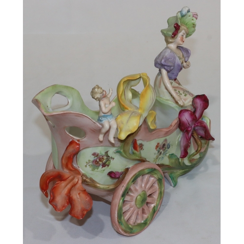 34 - A Continental china jardiniere in the form of a shoe on wheels with raised figure and cupid motif, a... 