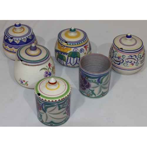 43 - A Poole Potter cylindrical jam pot with cover and multi-coloured fruit and leaf decoration, another ... 