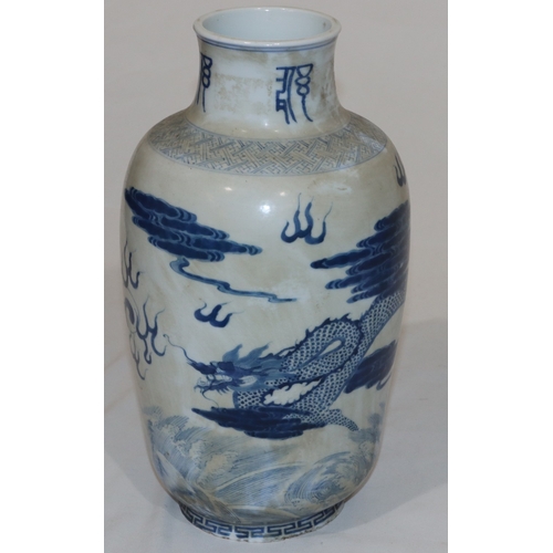 50 - An Oriental round bulbous thin necked vase on blue and white ground with dragon, cloud and inscripti... 