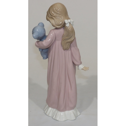 66 - A Nao figure of a young standing girl in pink nightdress holding a teddy bear, 31.5cm high