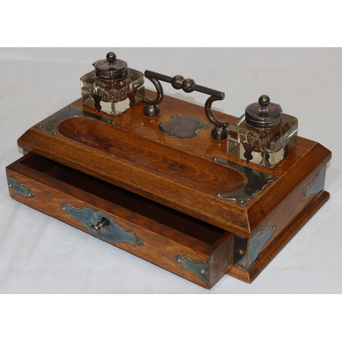 703 - A Victorian oak rectangular shaped inkstand with silver plated centre handle and various silver plat... 