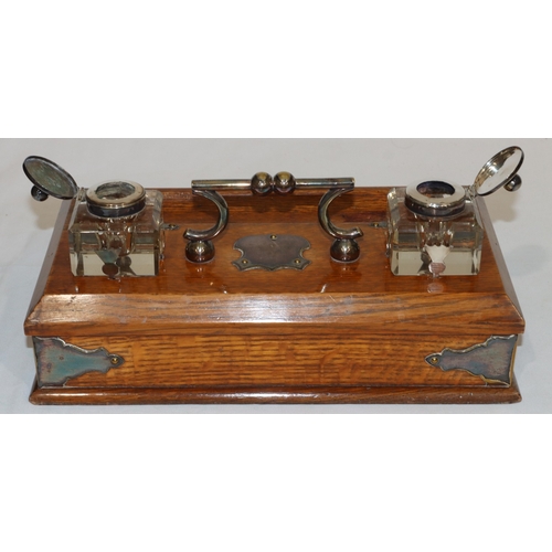 703 - A Victorian oak rectangular shaped inkstand with silver plated centre handle and various silver plat... 