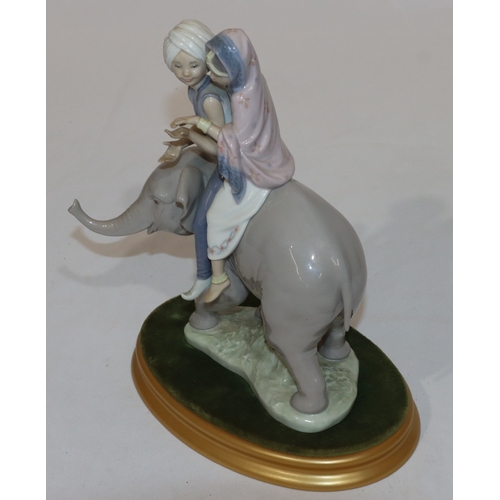 90 - A Lladro group of 2 Eastern figures seated upon elephant with oval gilt base, 23cm high without base