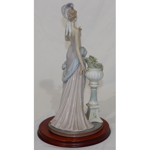 91 - A Lladro figure of a 1920's standing lady, on wooden base, 37cm high without base