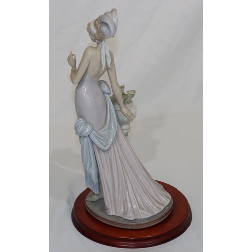 91 - A Lladro figure of a 1920's standing lady, on wooden base, 37cm high without base