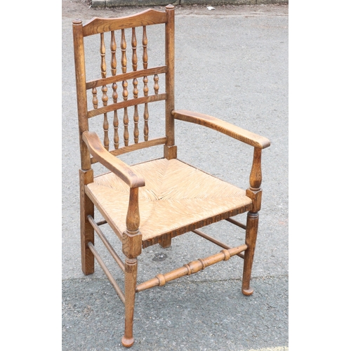 922 - An oak spindle back armchair with rush seat and turned stretchers