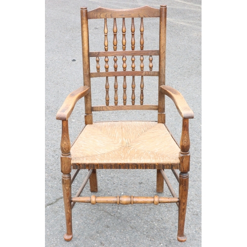 922 - An oak spindle back armchair with rush seat and turned stretchers