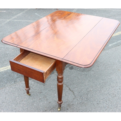 924 - A large 19th Century mahogany Pembroke table with 1 end drawer on round turned legs and brass castor... 