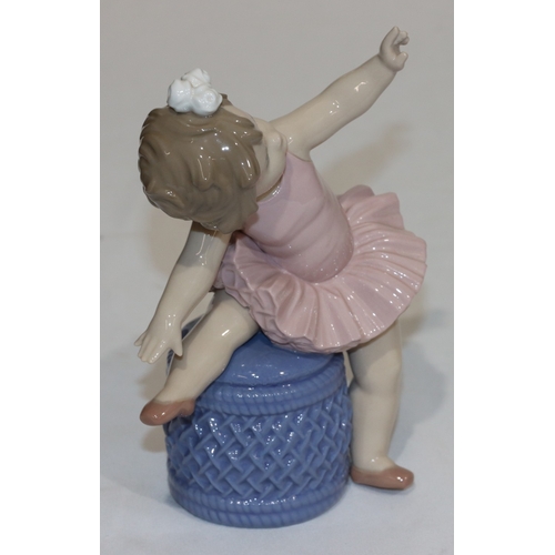 98 - A Lladro figure of a young ballerina child seated on a pouffe, 16.5cm high